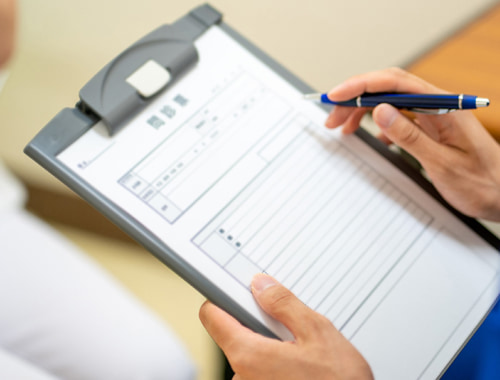 泌尿器科関連疾患で受診する患者さんが問診票を書く様子